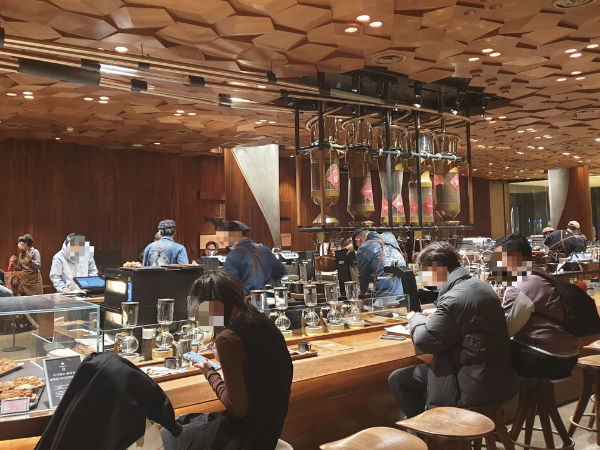 바테이블에 사람들이 앉아 있는 모습. 안쪽 바리스타들은 열심히 추출 중