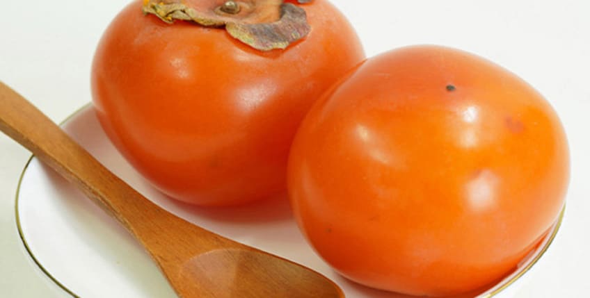 홍시 두개가 접시에 담겨 있다