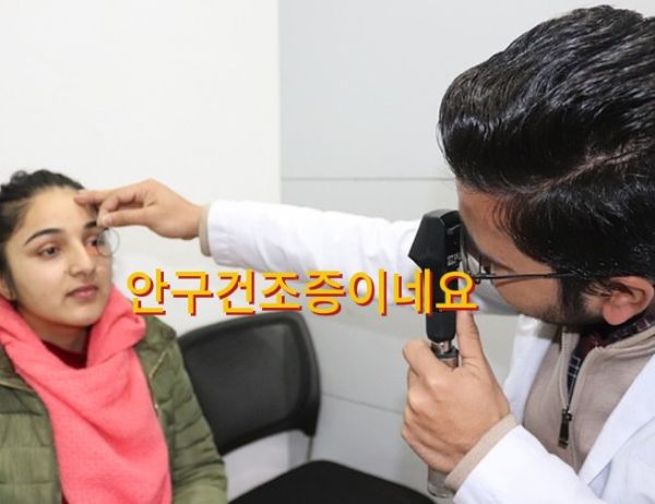 의사가 여성의 눈을 자세히 들여다 보는 장면