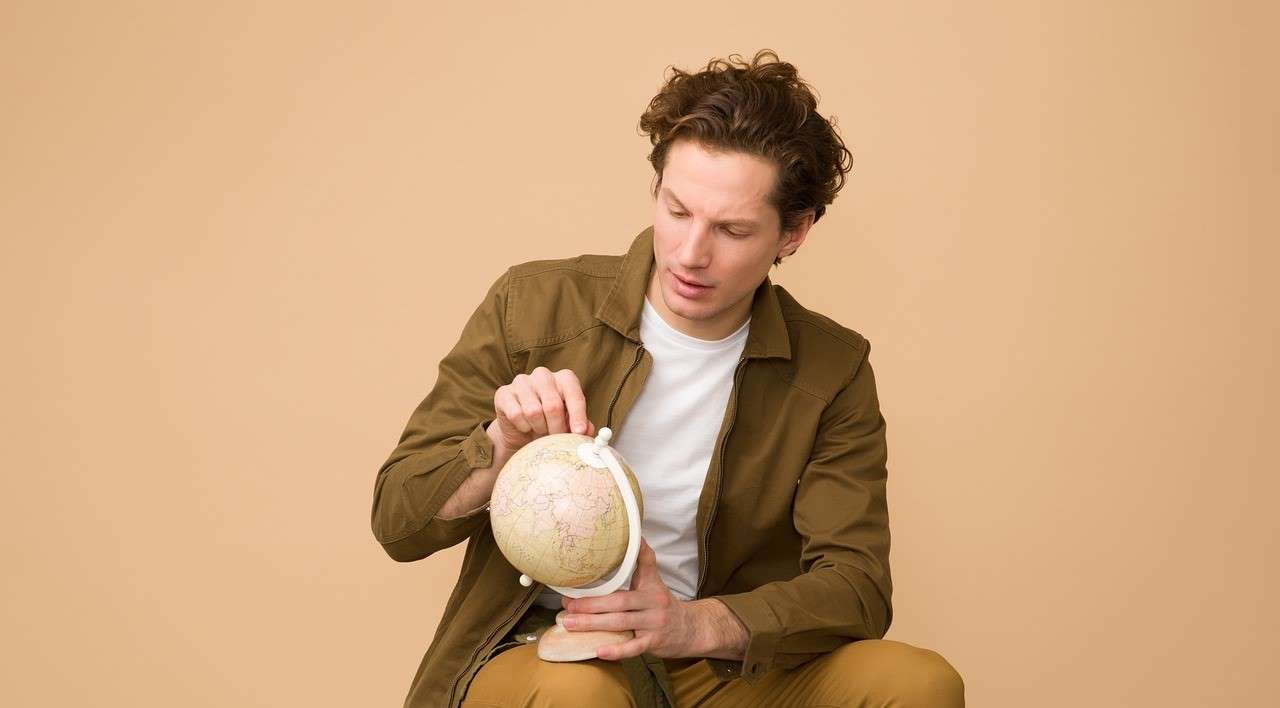 지구본을 보며 여행지를 정하고 있는 남성의 모습