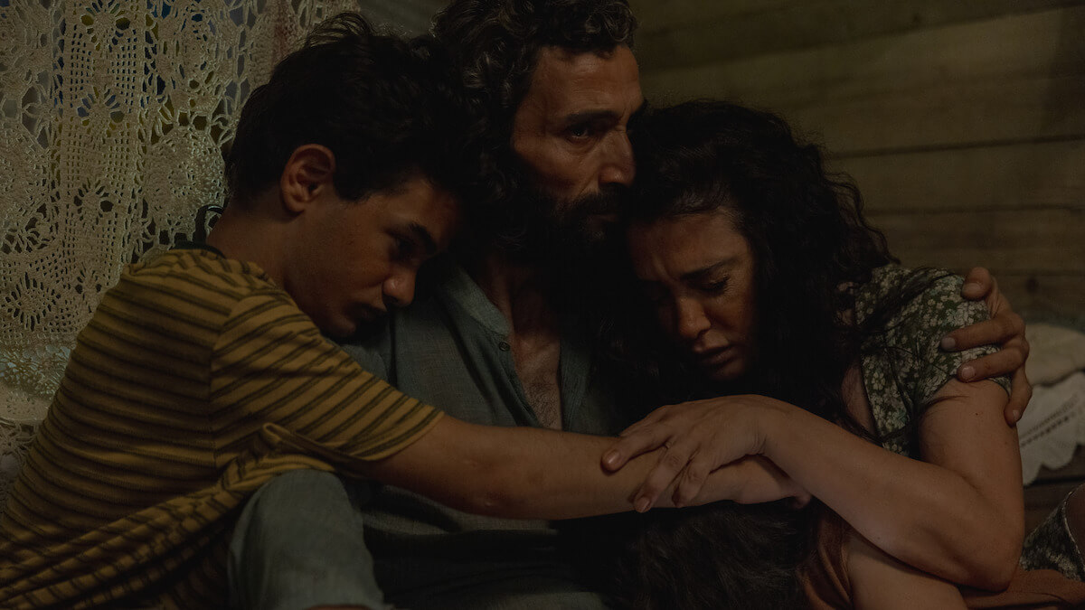 넷플릭스 신작 〈The Sand Castle〉: 어두운 실내에서 가족이 서로를 꼭 끌어안고 있는 장면