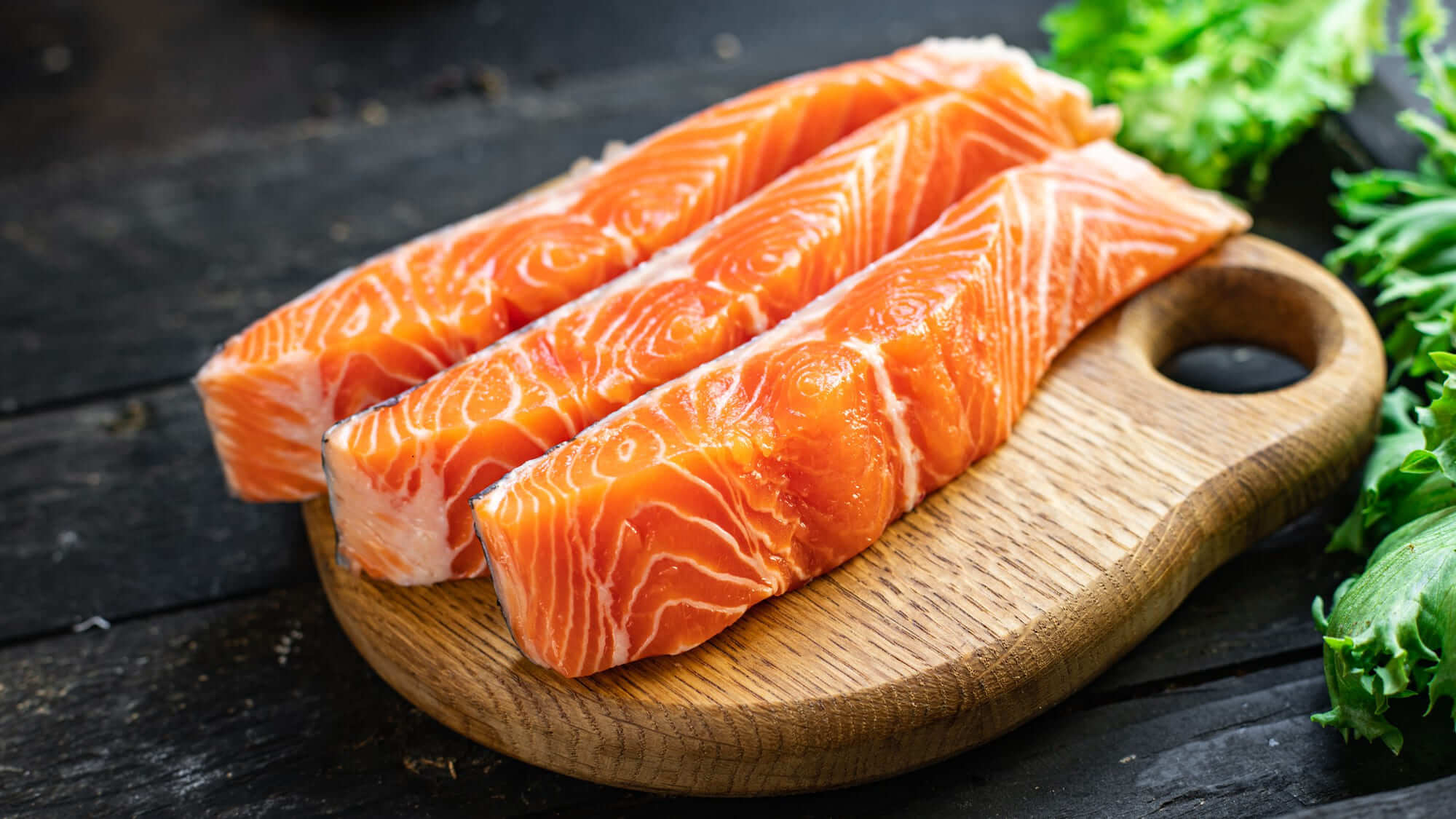 나무 도마 위에 올려진 연어 필렛, 신선한 채소와 함께한 건강한 재료