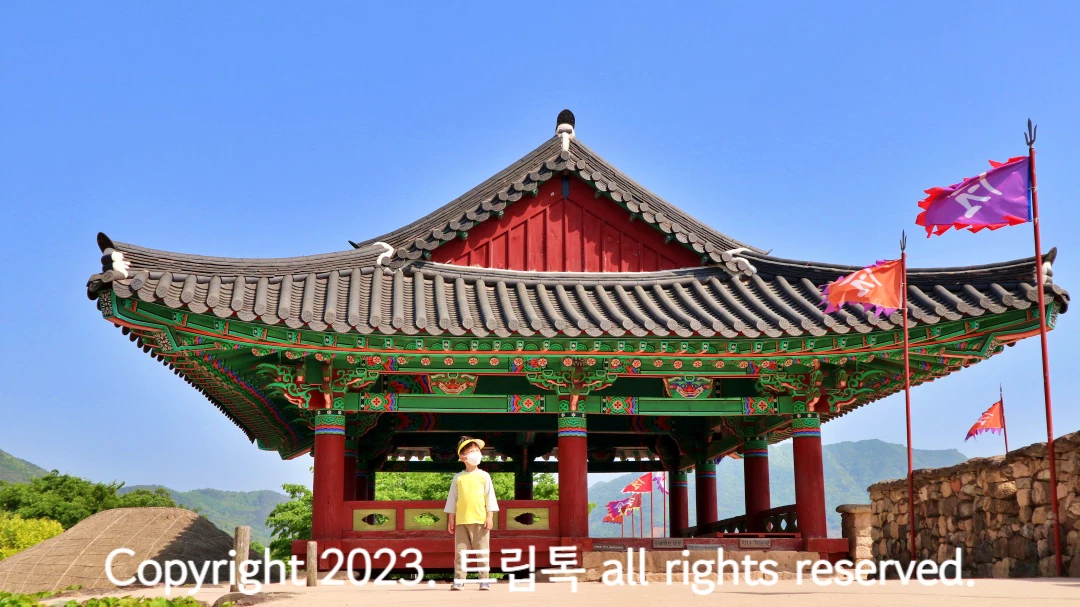 낙안음석 성벽길에 있는 기와집 같은 정자와 깃발