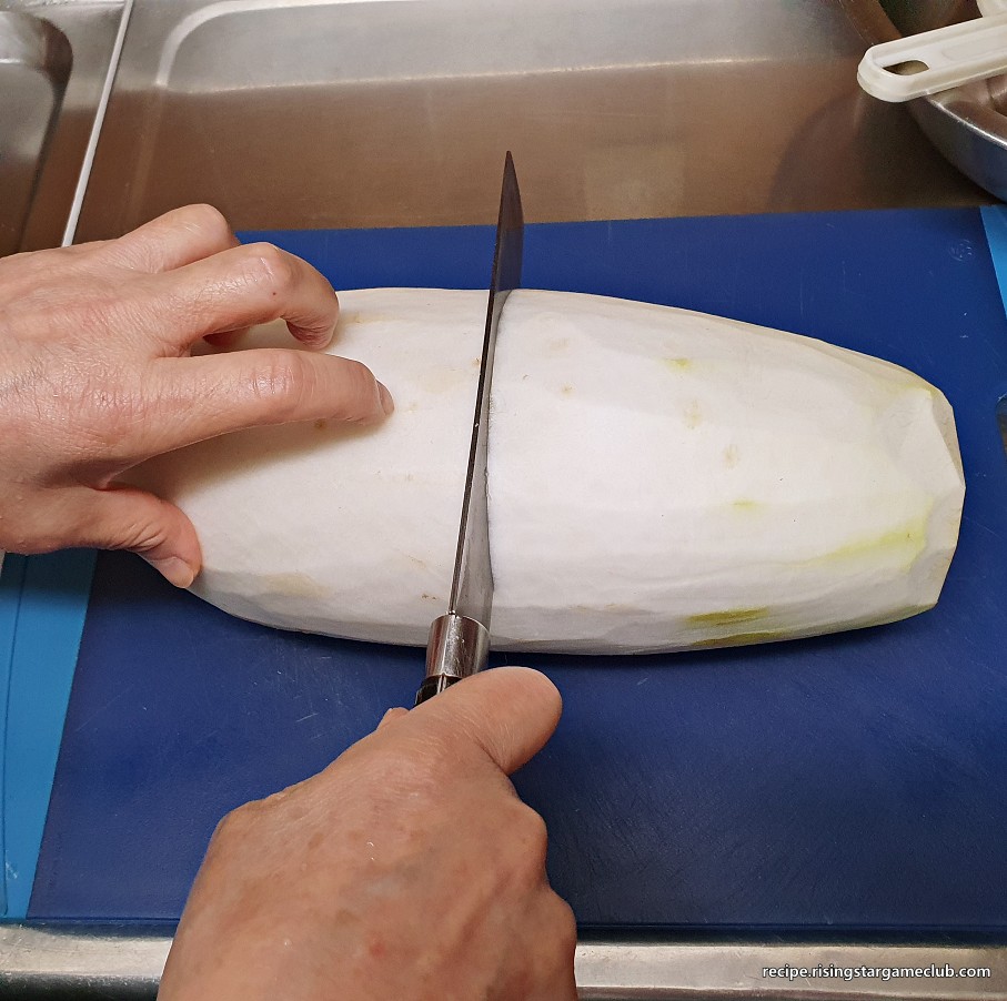 무생채 무침에 들어갈 무를 반으로 자르는 사진