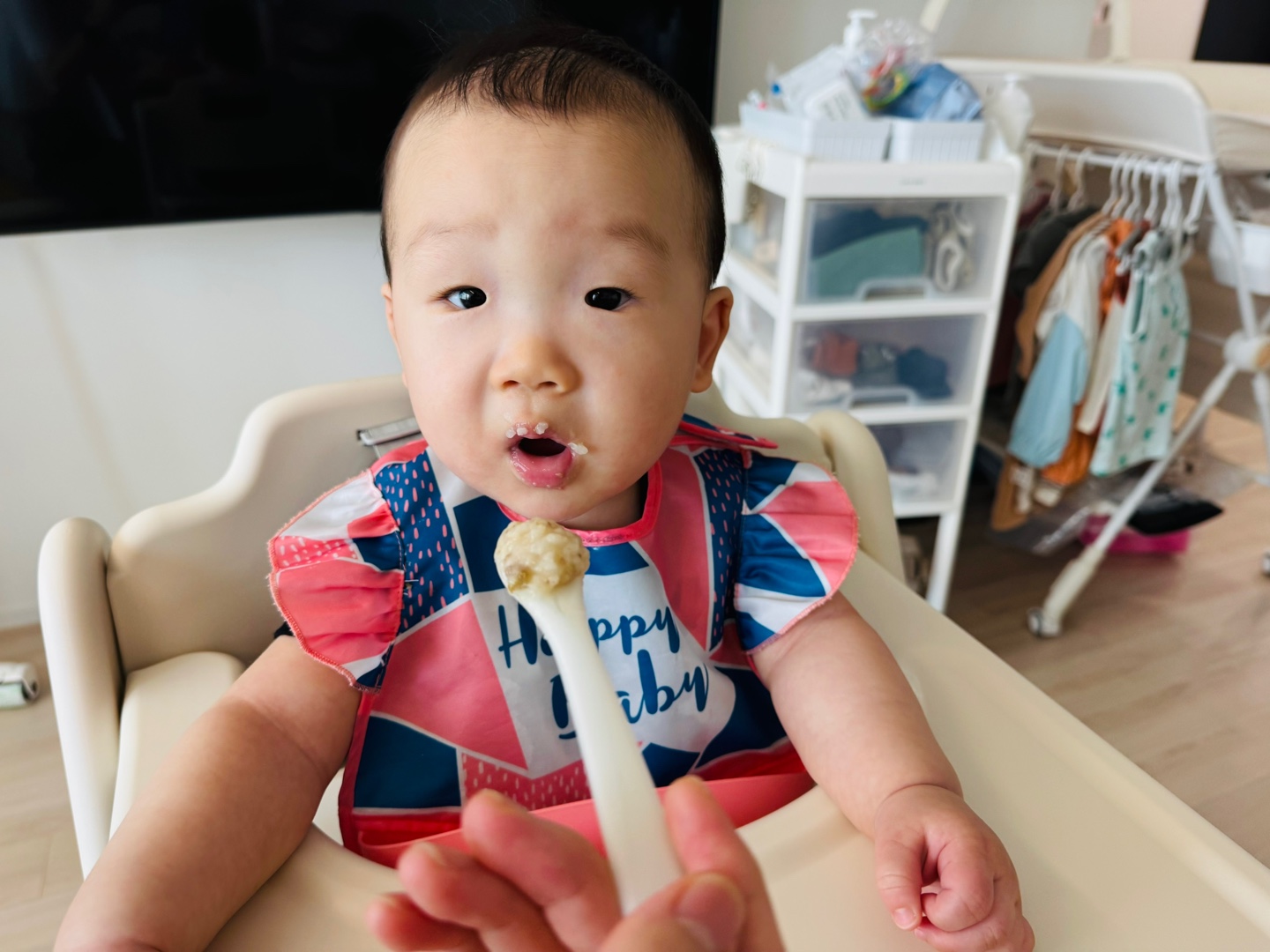 숟가락에 담긴 가지죽을 바라보며 입을 쩍 벌리고 먹을 준비를 하는 찬솔이