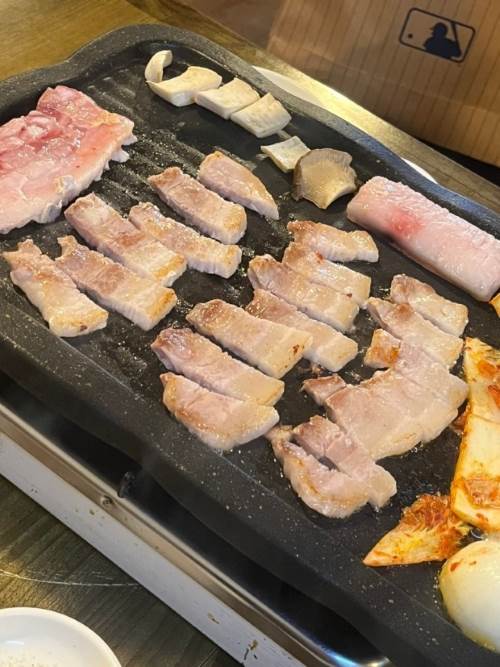 불판에 삼겹살을 맛있게 굽고있다.