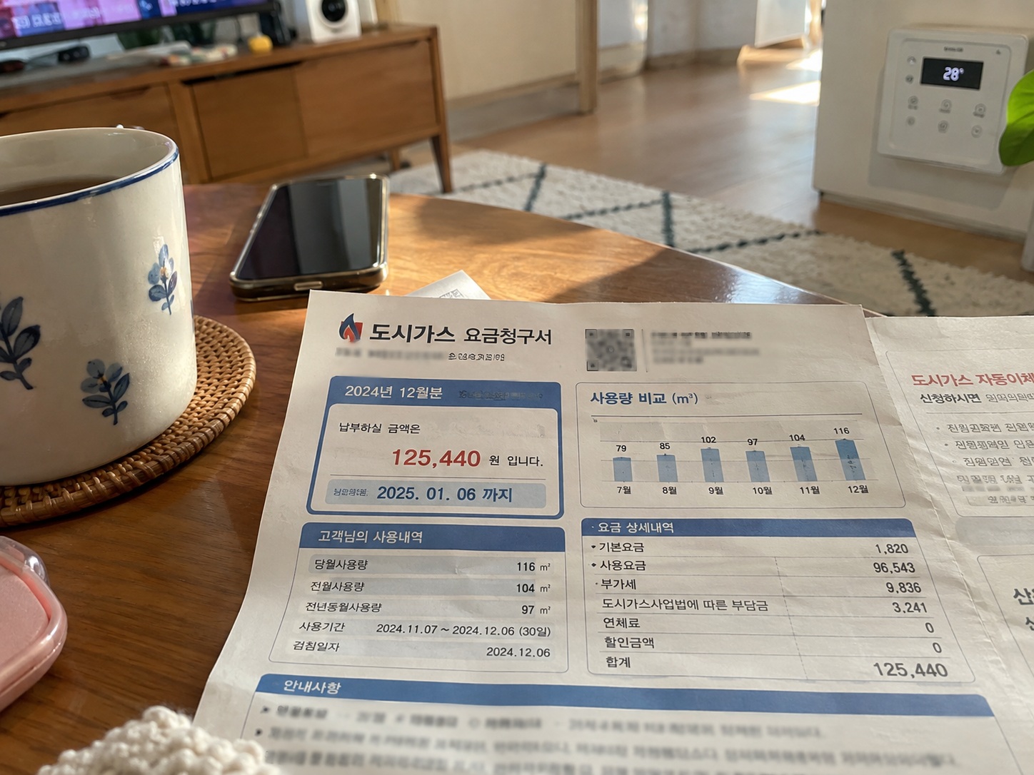 겨울철 에너지바우처 난방비 지원을 알아보기 위해 거실 테이블 위에 펼쳐놓은 도시가스 요금 고지서