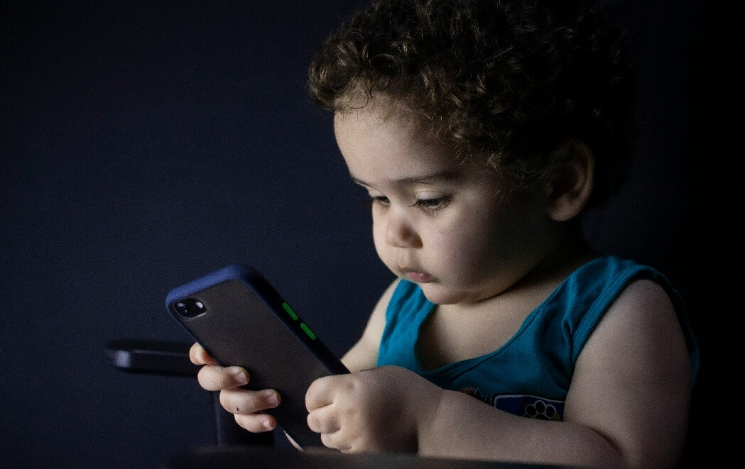 아이폰을 보고 있는 어린 아이