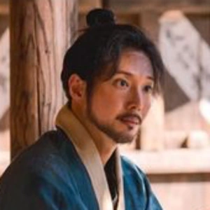 수염과 상투를 두르고 마루에 앉아 있는 사극 드라마 혼례대첩의 안동건 캐릭터