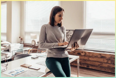 테이블에 앉아 노트북 컴퓨터로 작업하는 여성