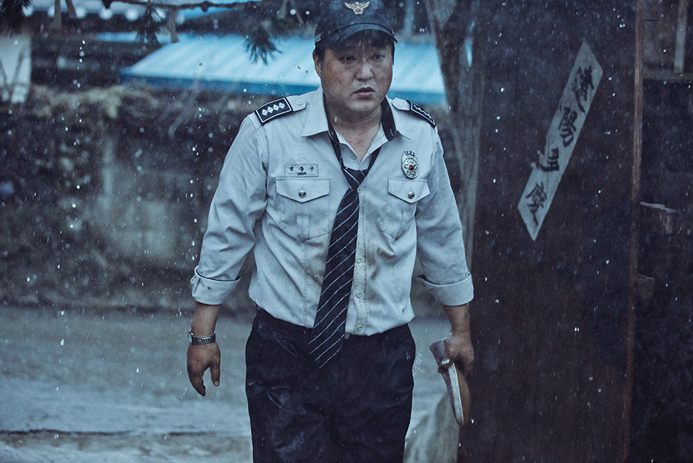 쏟아지는 빗속에서 경찰복을 입은 종구가 긴장된 표정으로 앞을 바라보는 장면