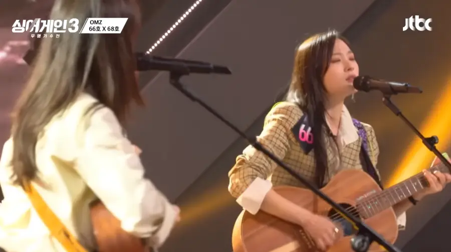 싱어게인3- 좌측 노란색 셔츠를 입고 긴생머리를 늘어뜨리고 스탠딩마이크에 노래하는 68호와 우측 노란색 자켓을 입고 긴생머리를 늘어뜨린채 갈색 기타를 치며 스탠딩마이크앞에서 진지하게 노래하는 66호