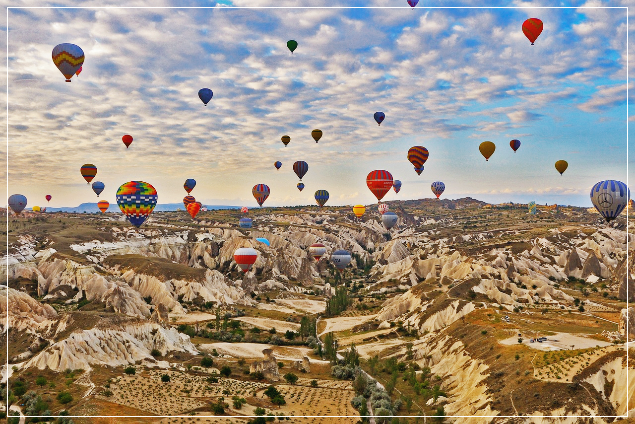 카파도키아의 독특한 지형과 그 위를 날고 있는 여러 개의 열기구들