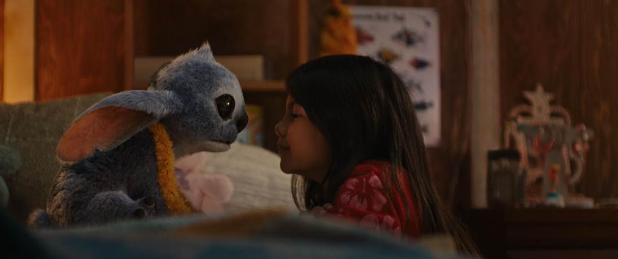 실사판 Lilo & Stitch의 한 장면 : 릴로와 스티치가 서로를 따뜻한 시선으로 바라보며 교감하는 장면