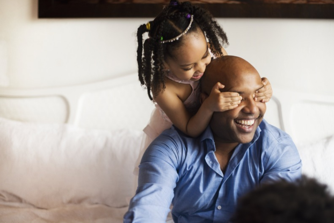 딸이 두손으로 아빠의 두눈을 막고 있다.