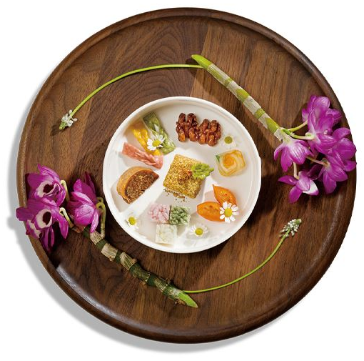 경복궁 생과방 대추인절미세트. 나무로 된 둥근 쟁반 위에 꽃 두 송이가 하나의 접시를 감싸고 있으며, 접시 안에는 행사에서 맛 볼 수 있는 대추인절미세트가 있다.