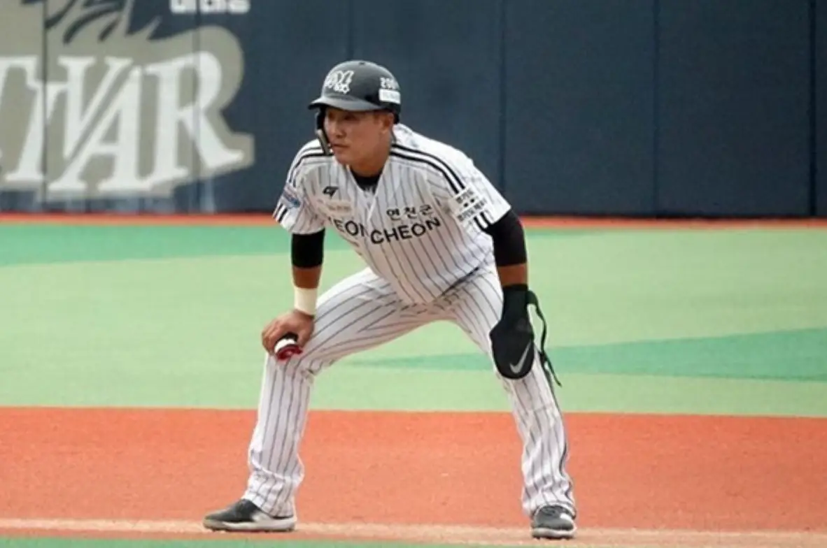 그라운드 위 흰유니폼을 입고 서있는 황영묵