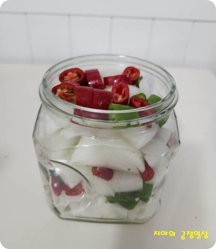 유리병에 담긴 썰어놓은 양파와 고추