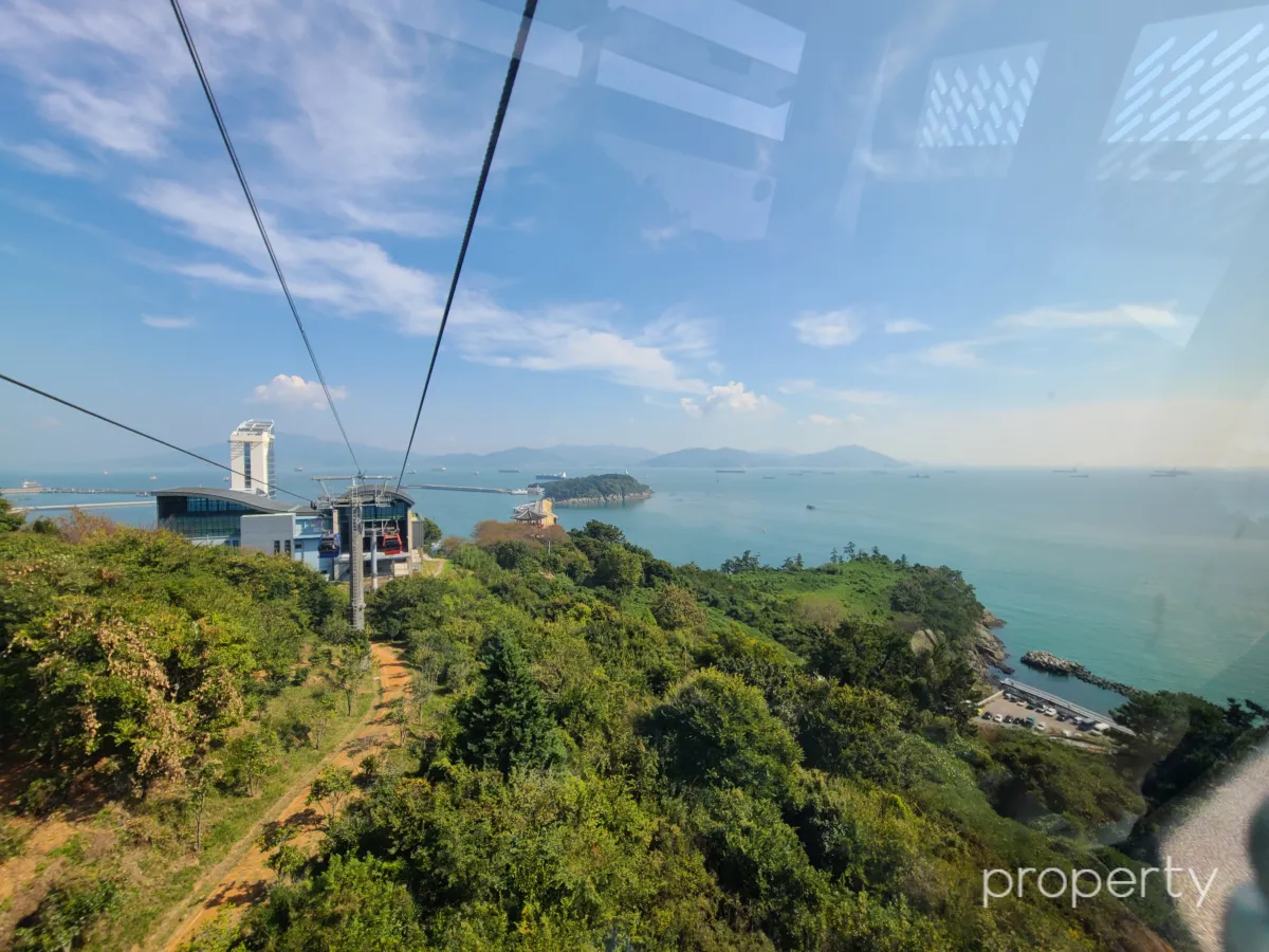 긴케이블-위에-케이블카들-파란하늘-흰구름-에메랄드빛-바다-수평선과-작은섬들과-오동도