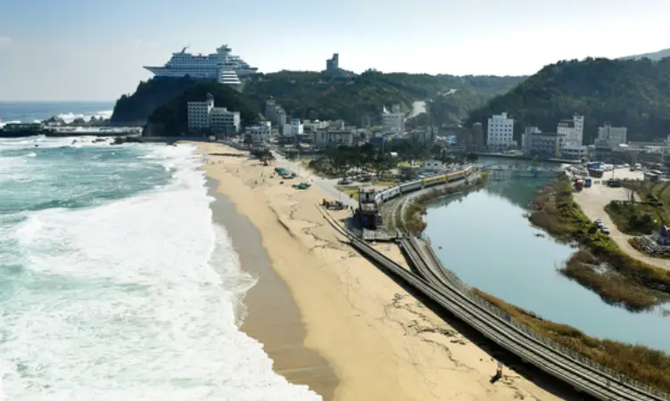 바닷가 바로 옆 철길이 길게 늘어선 모습