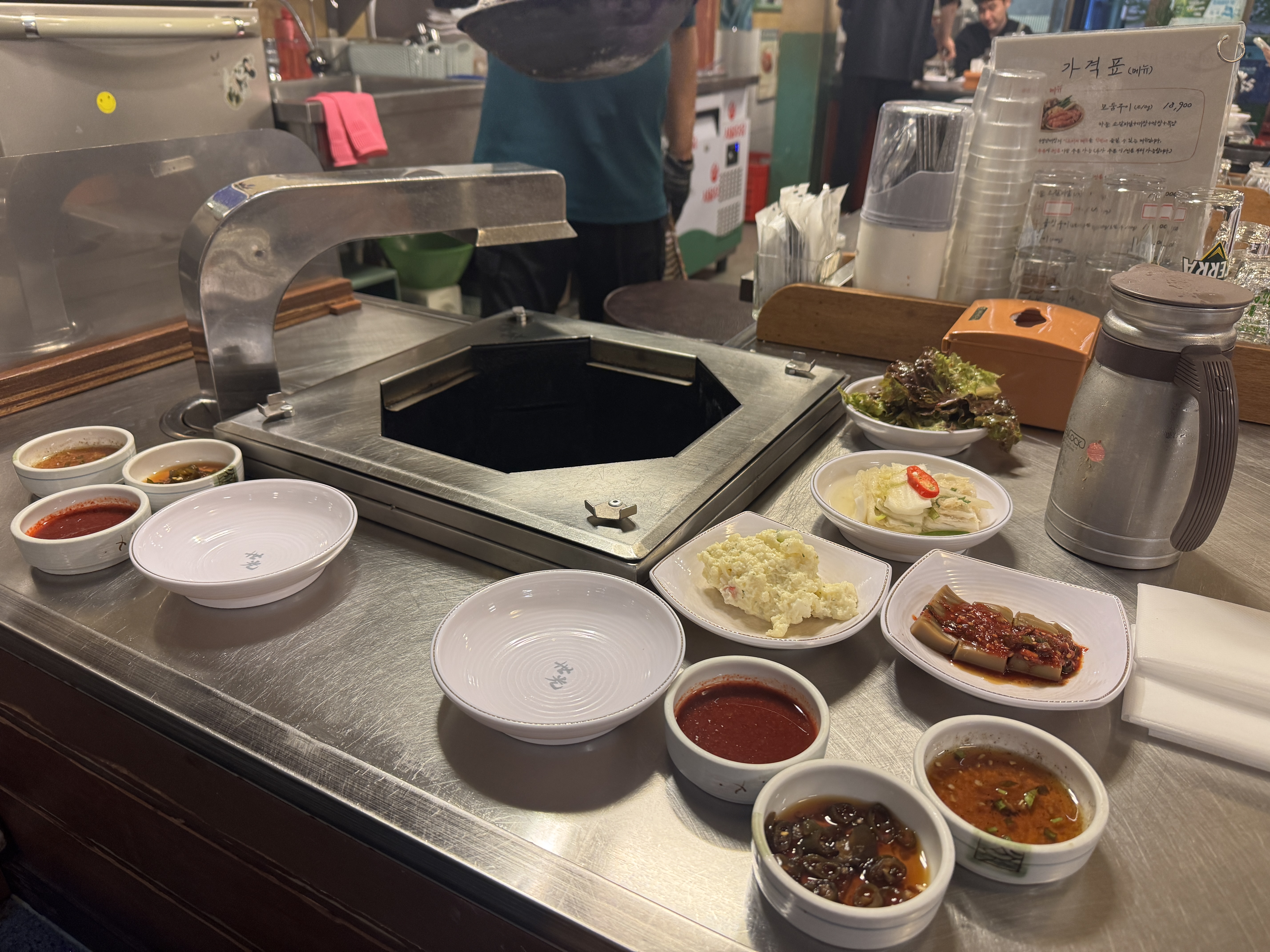 세광양대창 정자점 밑반찬 전체 세팅 &mdash; 불판 앞에 양파절임&amp;#44; 감자샐러드&amp;#44; 묵무침&amp;#44; 양념장&amp;#44; 상추가 세팅된 테이블 전경