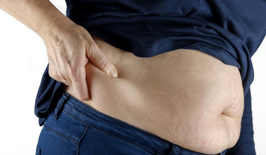 남성이 자신의 옆구리 뱃살을 손으로 짚고 있다