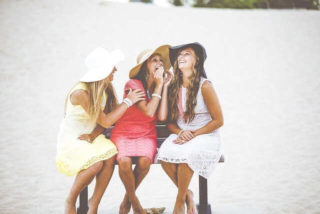 벤치에 앉아 즐겁게 웃는 세명의 소녀들