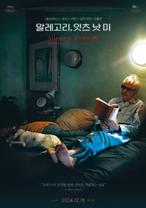 film: Allegory It’s Not Me 침대 위에 주인공이 앉아 책을 읽고 있습니다. 그리고 강아지 한 마리가 우워서 자고 있습니다.