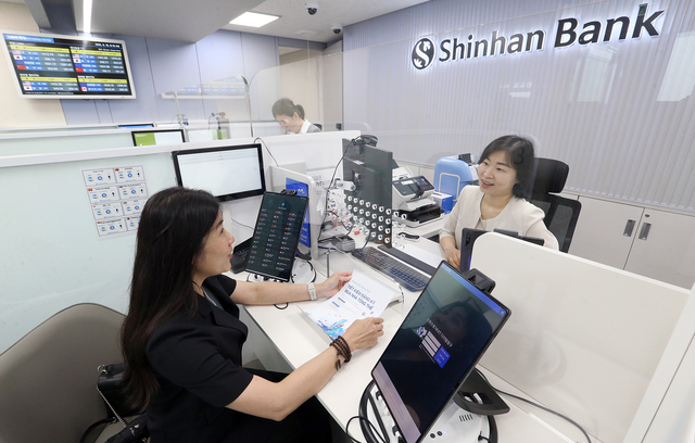 외국인 고객이 19일 ‘안산외국인중심영업점’에서 은행 직원과 업무를 진행하고 있다.