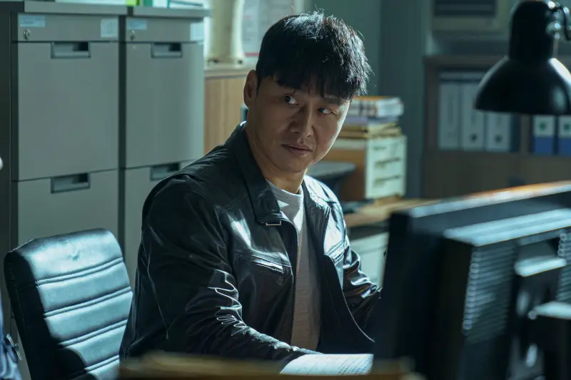 경찰 사무실을 배경으로 누군가를 무섭게 노려보는 재환