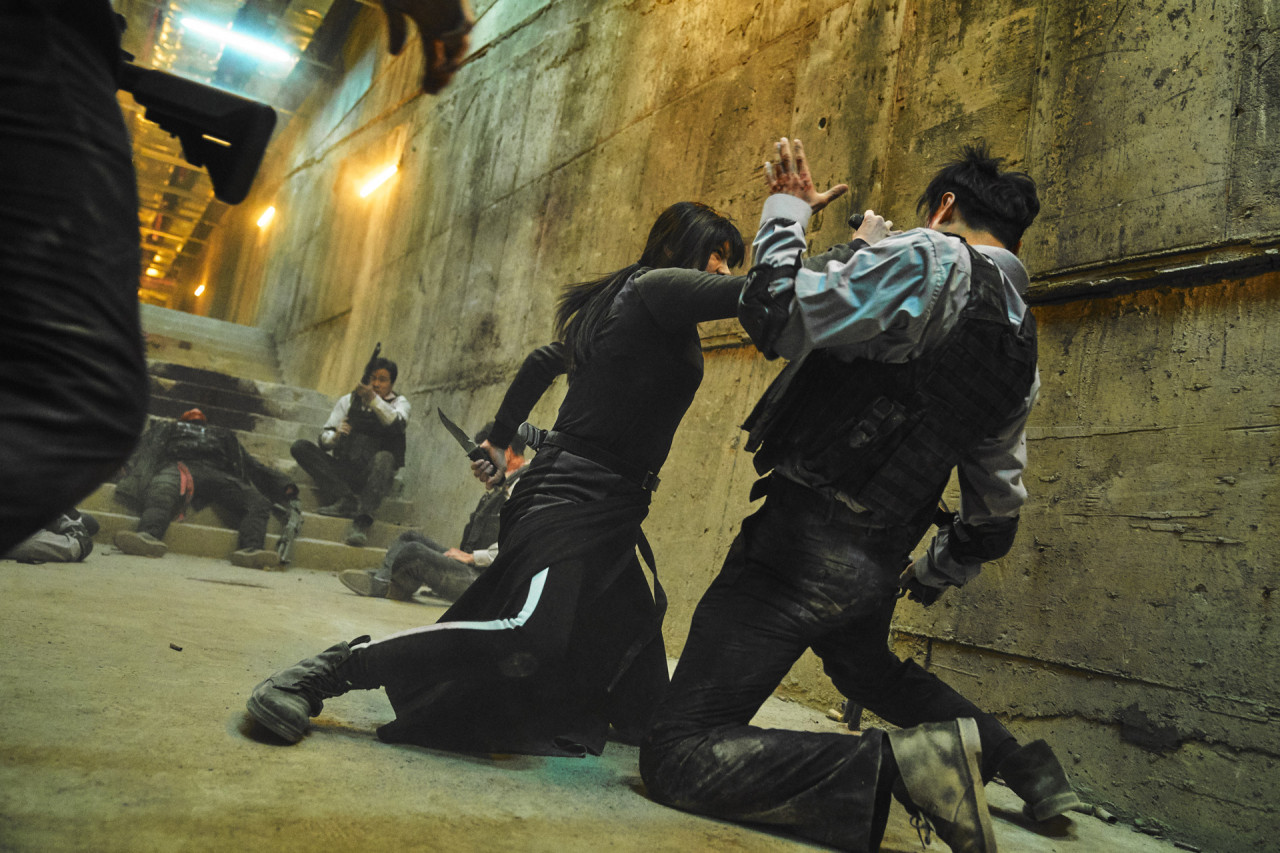 액션씬 남자들과 여자 한 명이 싸우고 있다.