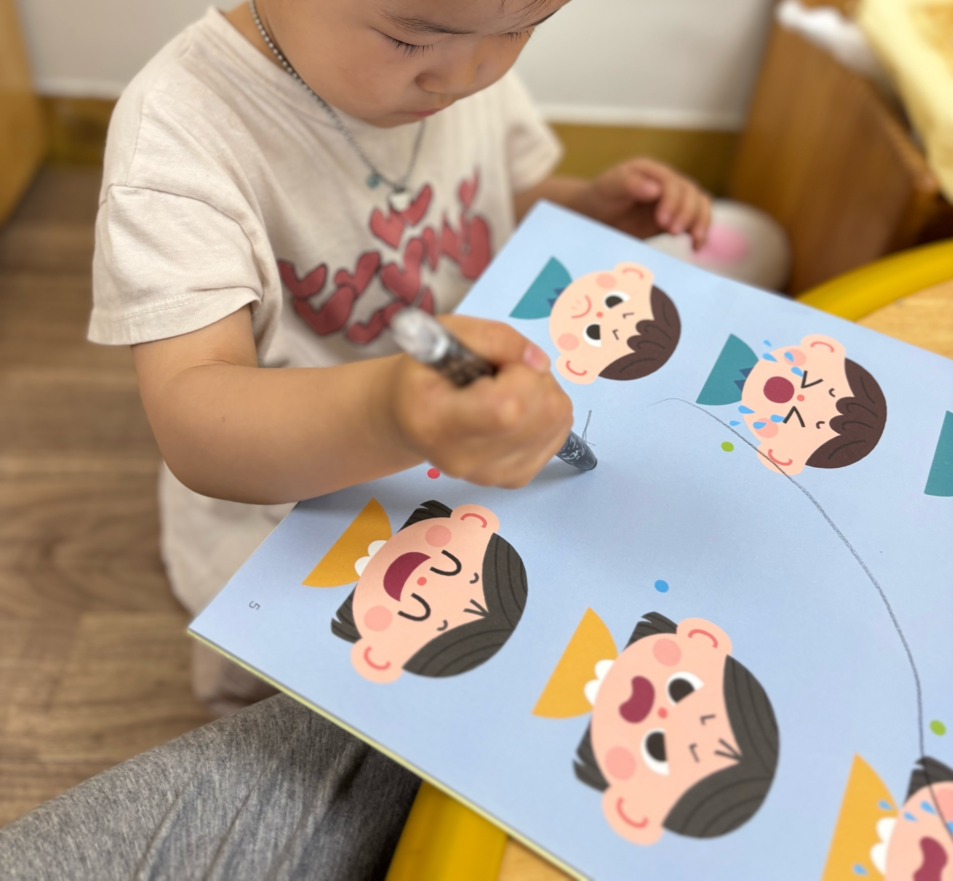 어린이집 아이마이미 프로그램에서 스티커 활동을 하는 아이