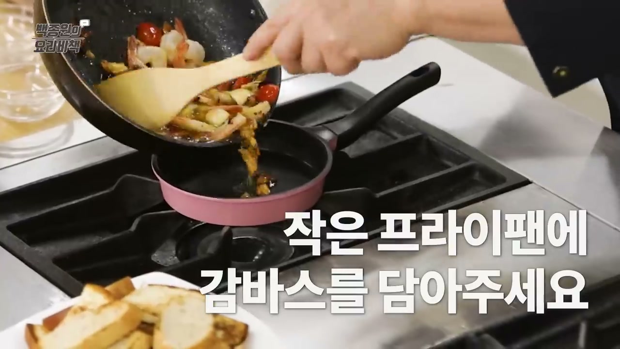작은 프라이팬에 감바스를 옮겨 담는 장면