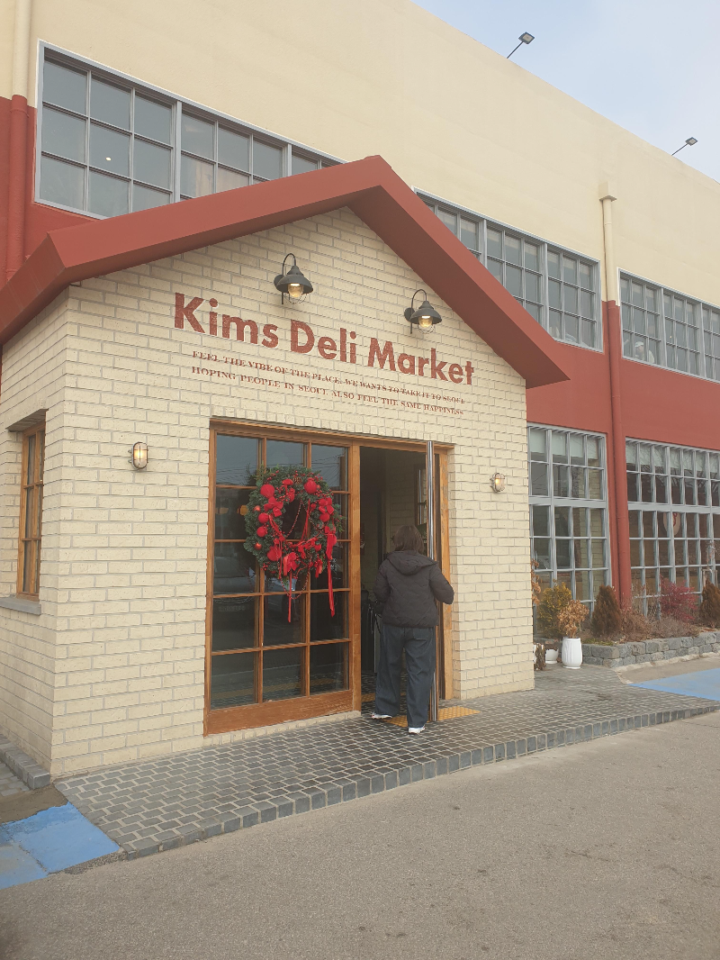 베이지색 건물에 적색으로 포인트를 준 킴스델리마켓 외관