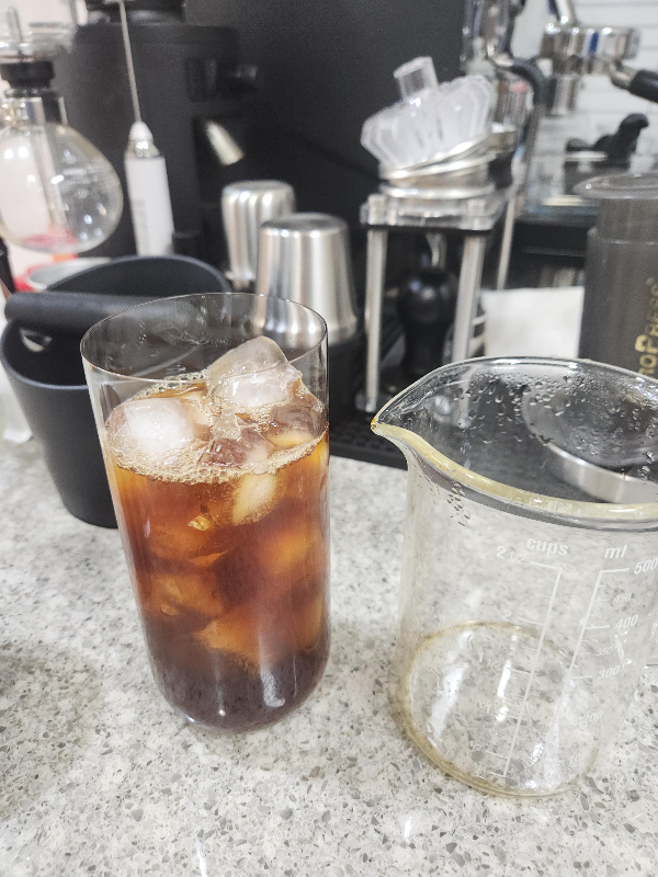 얼음컵에 추출된 커피가 부어진 모습. 빈 서버가 함께 있다.
