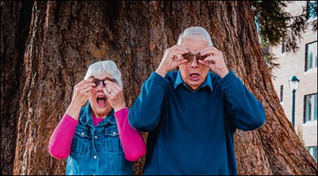 노년의 부부가 나무 앞에 서 있음