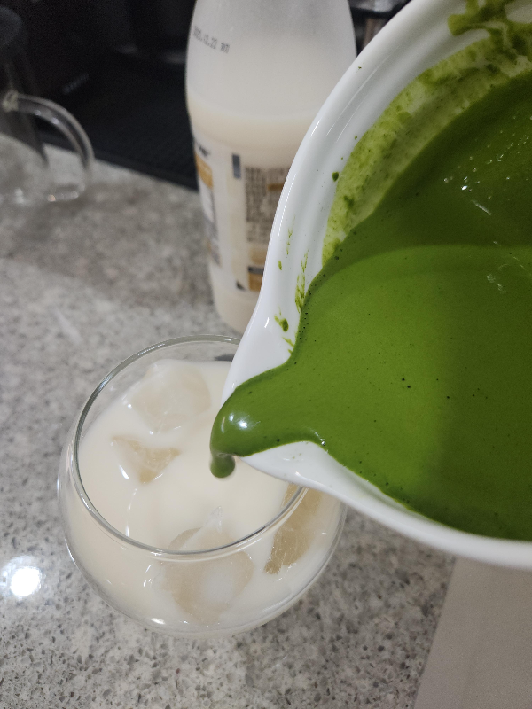 얼음과 막걸리가 담긴 컵에 말차를 넣는 모습