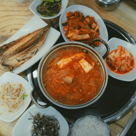 “김치찌개와 밑반찬, 밥이 한 상 차려진 전통 한식 식사