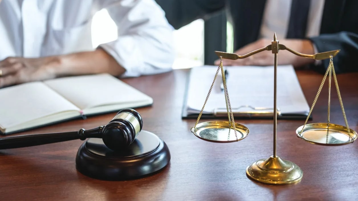 책상 위에 재판봉과 저울이 있는 모습