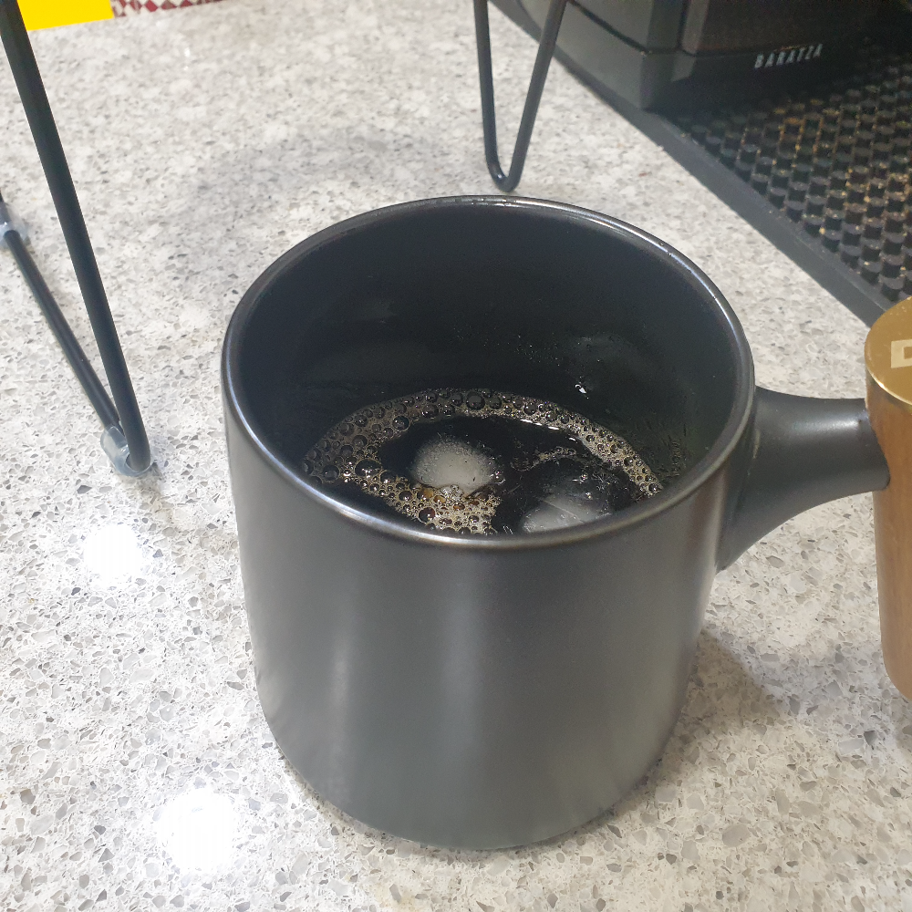 컵안에 커피와 얼음이 담겨 있다.