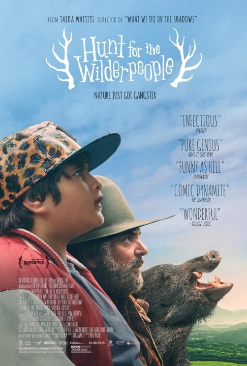 &quot;영화 'Hunt for the Wilderpeople'의 포스터로, 앞을 바라보는 소년과 수염이 덥수룩한 남성이 나란히 서 있고, 그 옆에는 멧돼지가 고개를 들고 있다. 포스터 상단에는 영화 제목이 사슴 뿔 모양의 장식과 함께 중앙에 배치되어 있으며, 감독 타이카 와이티티의 이름과 영화에 대한 호평 인용구들이 함께 포함되어 있다. 자연을 배경으로 따뜻하고 유쾌한 분위기를 전달한다.&quot;