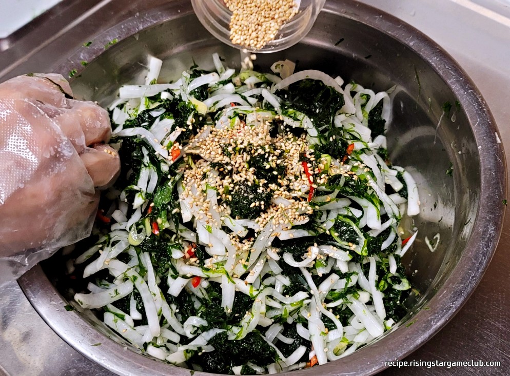 버무려진 파래 무침에 통께를 뿌리는 사진