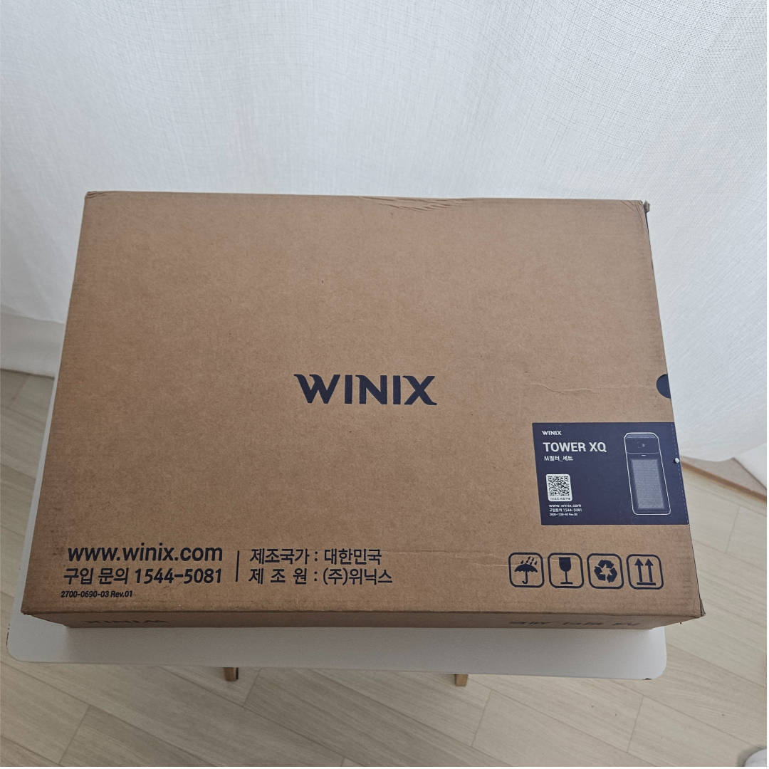 위닉스 공기청정기 필터 박스를 담은 이미지로, 실내 공기질 관리와 필터 교체의 중요성을 강조하는 장면