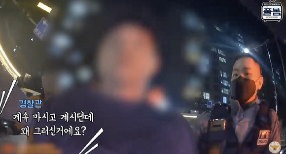 아파트단지 앞에 세워진 차량 운전석에서 아산화질소 가스통에 주입기를 연결해 흡입하던 30대 남성이 붙잡히는 장면. [사진=유튜브 채널 &#39;경찰청&#39;]