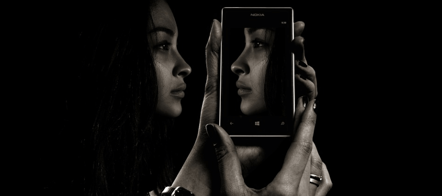 어두운 공간에서 스마트폰을 보고 있는 여자