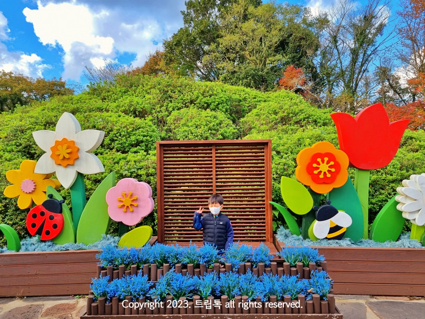 나무로 커다란 꽃장식이 되어있고 그 가운데 아이가 있다