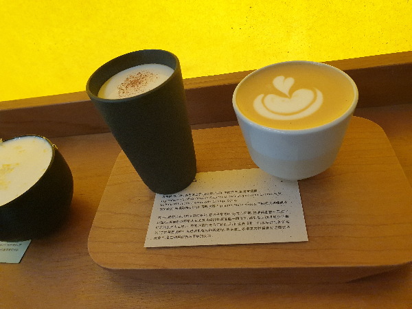 노란 조명 벽면 앞에 놓인 음료 3가지