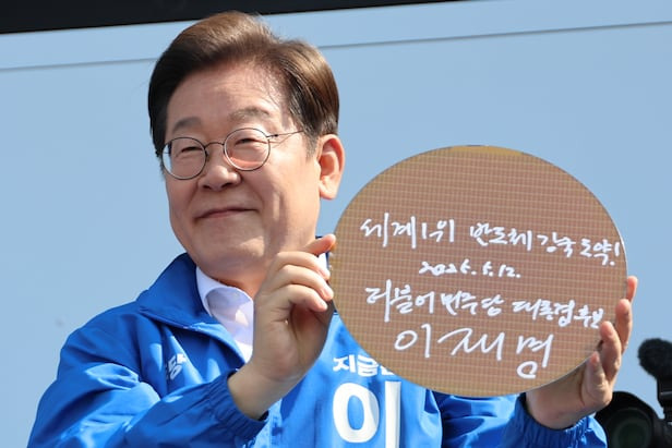 이재명 대통령이 지난달 12일 경기 화성시 동탄 센트럴파크 음악분수중앙광장에서 '세계 1위 반도체 강국 도약!'이라고 쓴 반도체 웨이퍼를 들어 보이고 있다