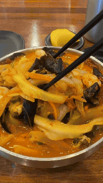 광교반점 핵짬뽕 휘젓는 장면 - 오렌지빛 국물에서 김이 오르는 매운짬뽕