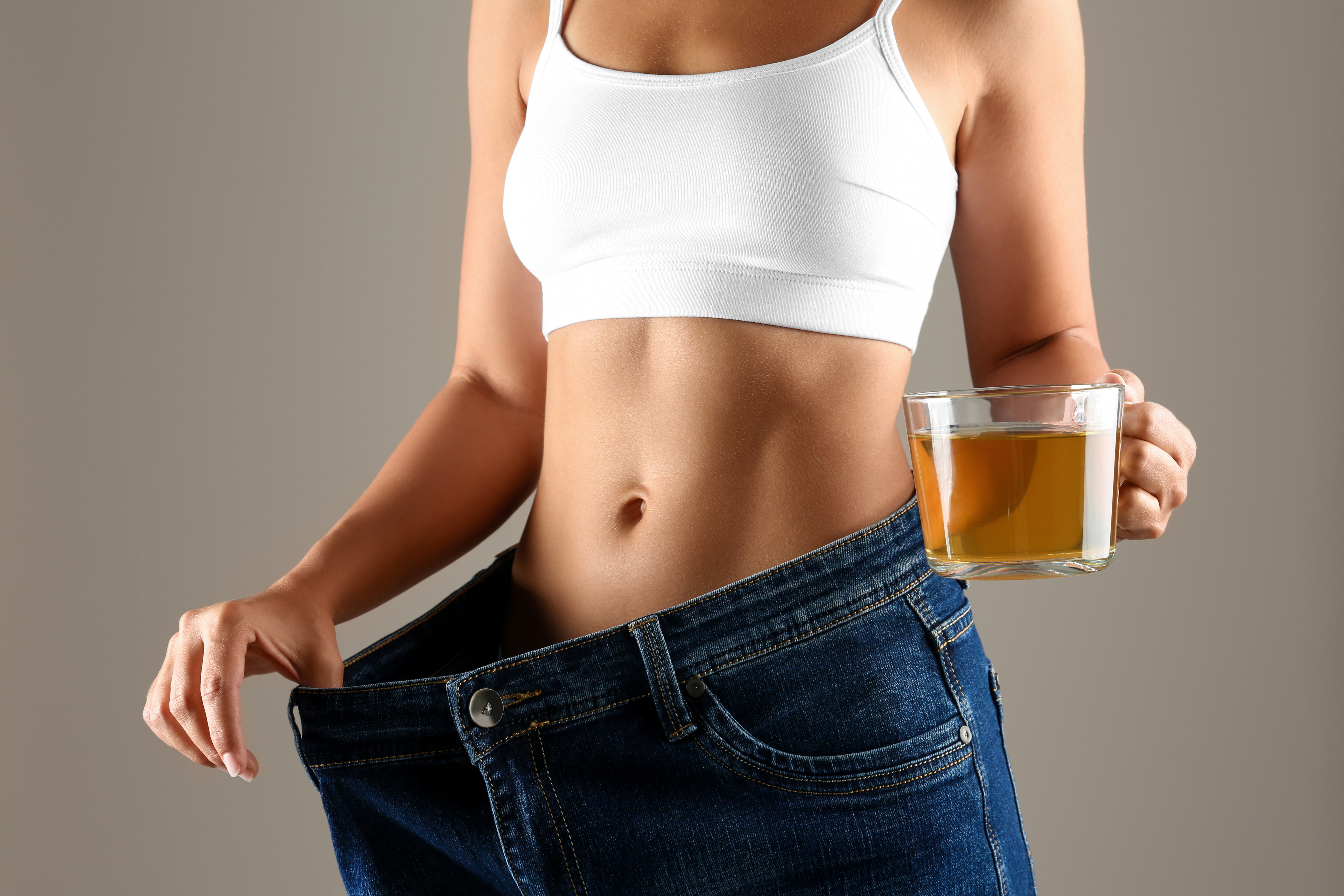 여름철 다이어트에 성공한 여성이 허브차가 담긴 컵을 들고 있는 모습